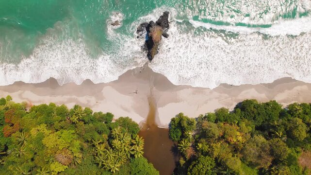 Aerial view of Espadilla beach with turquoise waves and jungle in Costa Rica