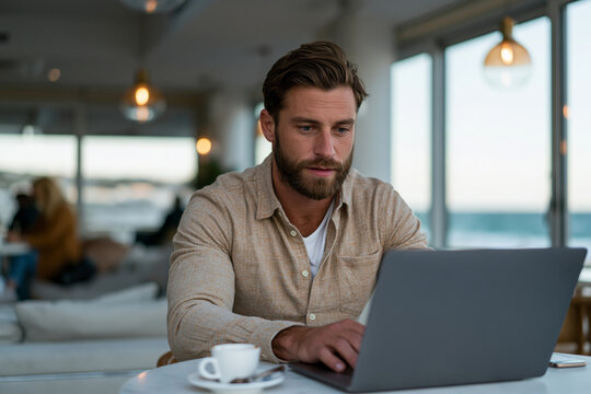 Young entrepreneur working from a beachfront coworking lounge with panoramic ocean views, stylish laptop setup, airy modern interior, natural daylight, premium advertising quality