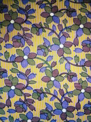 Seamless floral pattern with blue purple flowers on a vibrant yellow and orange vertical striped...
