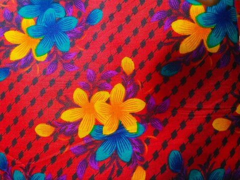 Bright colorful floral pattern with yellow and blue flowers on a vibrant red background for summer fabric or textile design