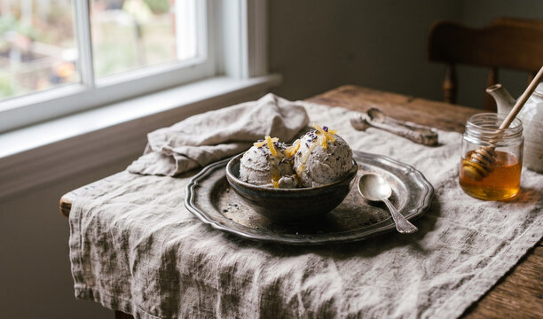 Artisanal Earl Grey tea gelato scoops with a touch of lavender, candied lemon peel, and a drizzle of honey, vintage pewter tray on linen, 