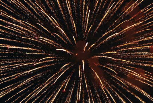Golden fireworks explosion burst texture background in night sky