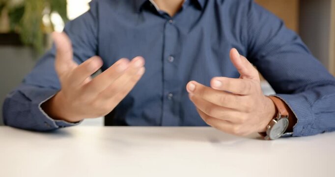 Close up of people talking to the camera, business professional sitting at desk, hands resting on ta