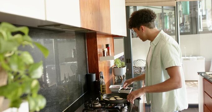 Lifestyle videos indoor of people doing activities at home, In kitchen, young man frying vegetables