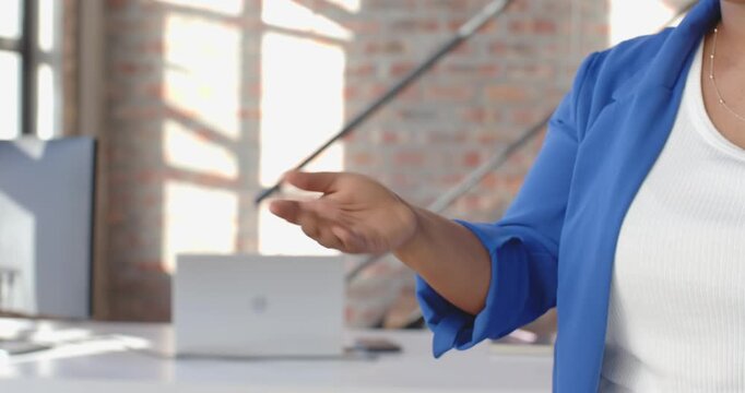 Close-up of people talking to the camera, hand gesturing in modern office with laptop nearby