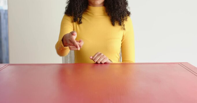 Close up of people talking to the camera, pointing down with both hands, woman in yellow sweater sit