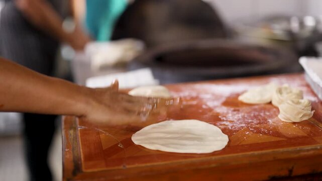 Indian Chef Flattening and Tossing Dough for Traditional Flatbread