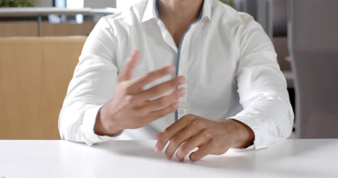 Close up of people talking to the camera, businessman in white shirt pointing during meeting in offi