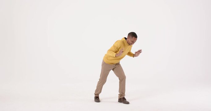 High-speed photography for dynamic scenes, man in yellow sweater dancing and expressing joy in minim