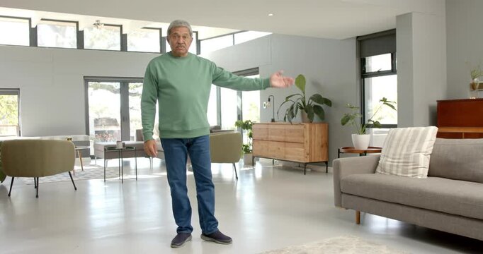 Close up of people talking to the camera, man in casual wear standing in living room, gesturing with