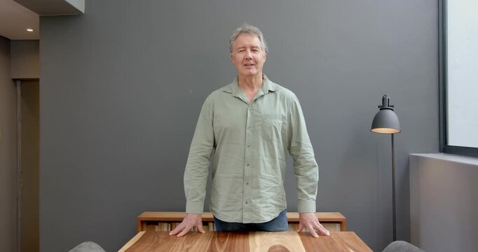 Close up of people talking to the camera, man standing at wooden table with hands on surface, lookin
