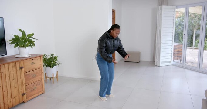 High speed photography for dynamic scenes, squatting indoors, woman in jacket exercising in living r