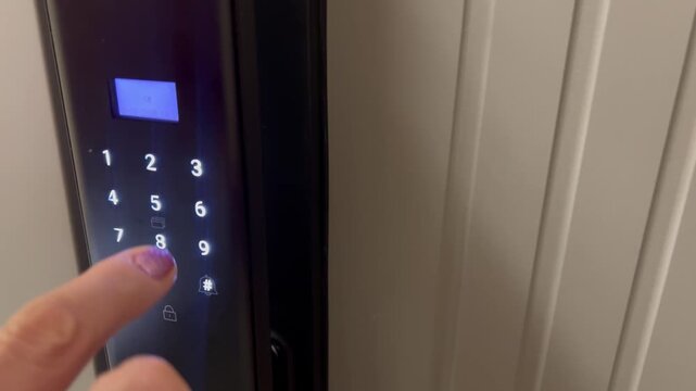 Close-up of a person pressing digits on an electronic keypad door lock, smart home security access control system with illuminated touchscreen panel in 4K.