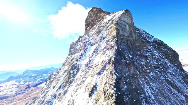 Stunning aerial drone footage capturing the iconic matterhorn mountain peak with snow during winter day.