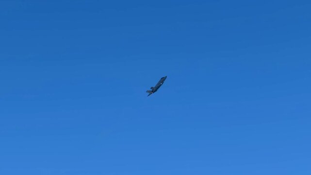 Military Stealth Fighter Jet Flying High in Clear Blue Sky