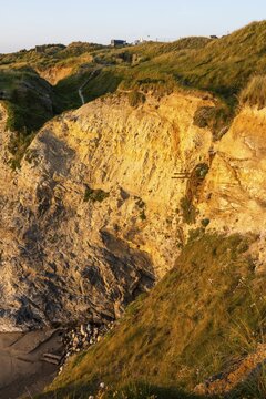 The Hidden Minecart, an old mining lorry or mine cart, in a rock face on Gwithian Beach. Evening, golden hour. Gwithian, Hayle, Cornwall, England, Great Britain