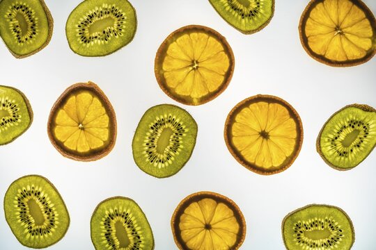 Orange and kiwi in slices, white background, food photography