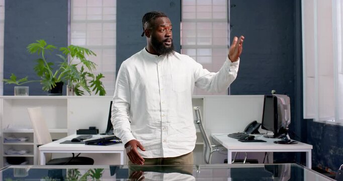 African American man in office giving presentation with confident expression