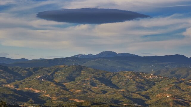 A cloud formation hovers over a wide, hilly landscape under a blue sky, view from Mystras to the mountains, Mystras, Mistra, UNESCO World Heritage Site, Medieval Byzantine ruined city, northwest of Sparta, foothills of the Tyagetos Mountains, Peloponnese, Peninsula, Greece