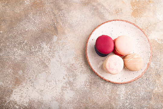 Macarons colourful cookies dessert on brown concrete, copy space, top view