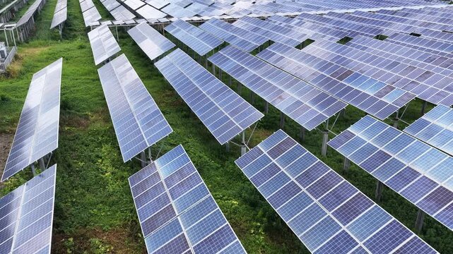 rows of solar panels on green grass field