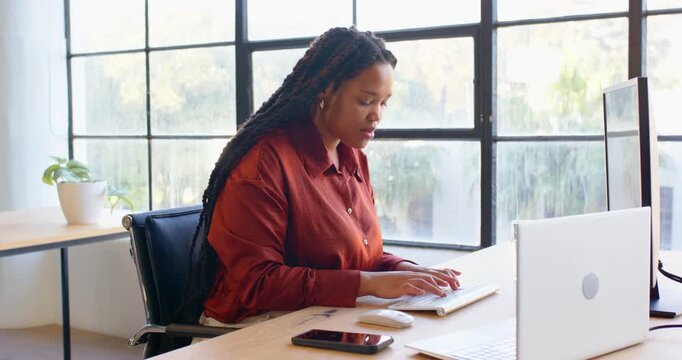 Businesswoman using desktop computer in modern office, focusing on work