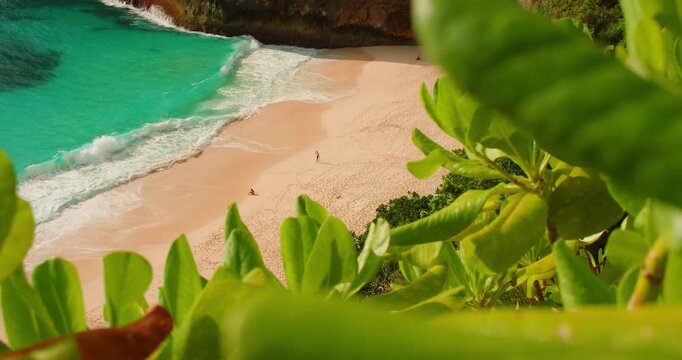 View from above turquoise ocean waves on sandy shore of Kelingking Beach Nusa Penida Bali