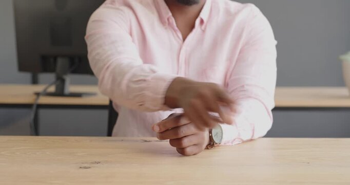 Business professional in pink shirt gesturing during meeting at office desk