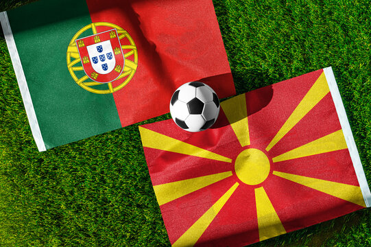 Portugal vs. North Macedonia football match. National flags on green grass with soccer ball in the middle. Football background for international match.
