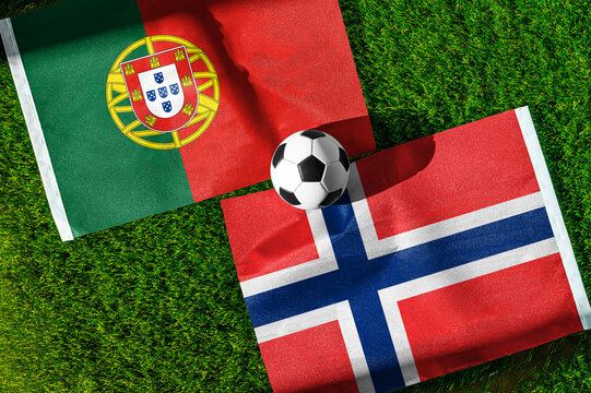 Portugal vs. Norway football match. National flags on green grass with soccer ball in the middle. Football background for international match.