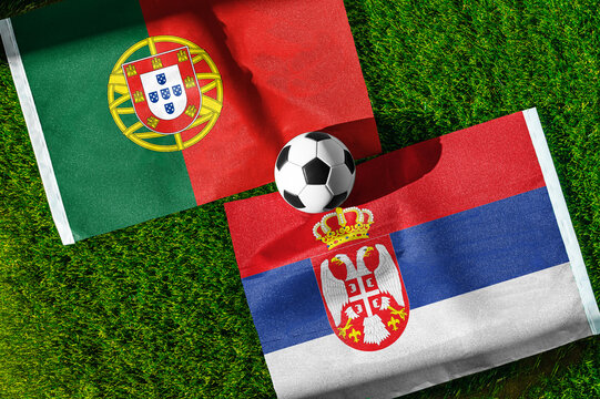 Portugal vs. Serbia football match. National flags on green grass with soccer ball in the middle. Football background for international match.