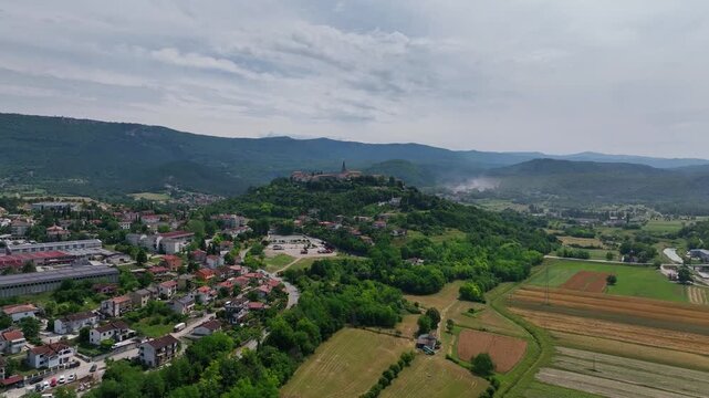 aerial drone view of Buzet historic medieval town in Istria Croatia at early summer showing old stone buildings, hilltop settlement, surrounding forests and green valley landscape