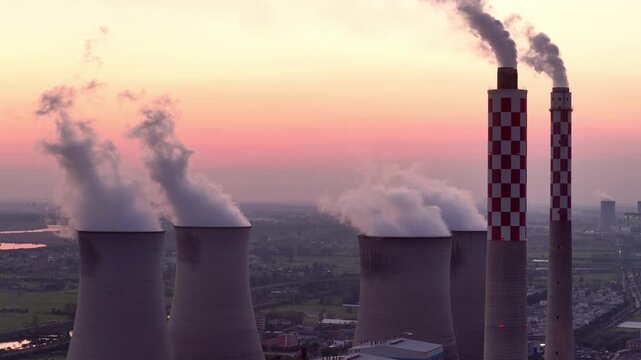 power plant cooling towers and smokestacks at sunset