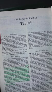 Opening to the book of Titus of the New Testament in the Holy Bible. New Revised Standard Version. Vertical video.