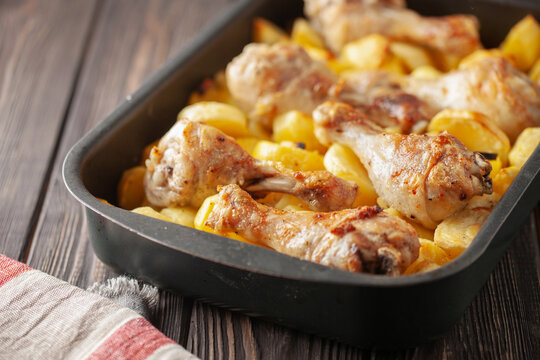 Roasted chicken legs with potatoes in  roasting pan. Comfort home food