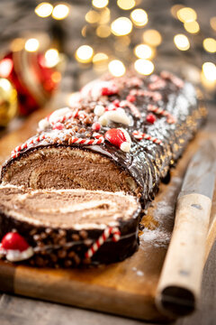 Christmas chocolate yule log cake with christmas light background