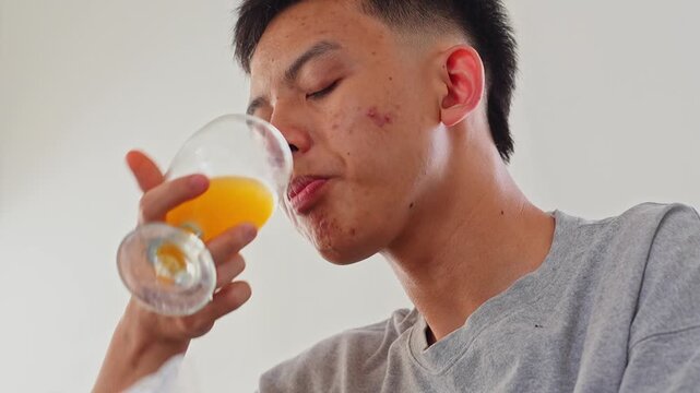 Close-up of man drinking orange juice after eating karedok or traditional indonesian salad