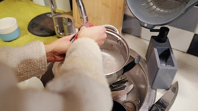 First person view captures everyday dishwashing, cleaning chores at kitchen sink