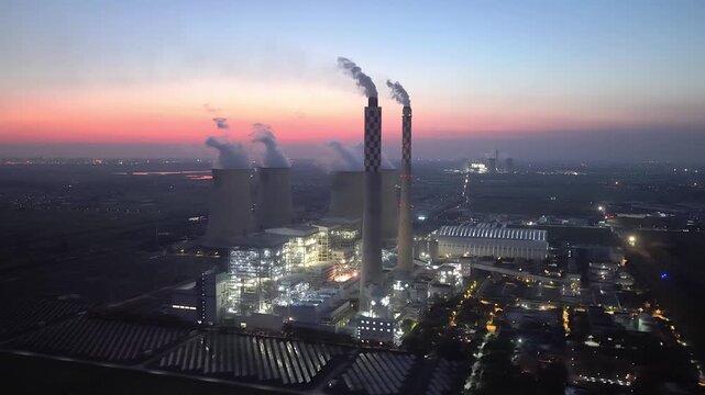 Thermal power plant panoramic view at dusk with cooling towers and smoke stacks
