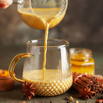 Golden Cinnamon  Turmeric Milk. Trendy hot Healthy drink with turmeric roots and spices. Indian Masala Haldi Doodh.