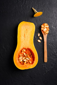 Butternut squash with seeds and wooden spoon in clean flat lay composition. Seasonal food styling with pumpkin and healthy autumn ingredients