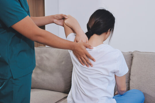 Professional doctor performing a spinal examination on a female patient.