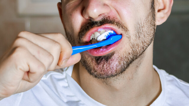 Man brushing teeth in bathroom, practicing daily hygiene and selfcare routine