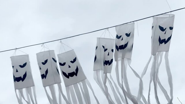 Spooky scary ghosts monster faces lanterns waving on wind on halloween background,autumn holidays,decoration and party concept.
