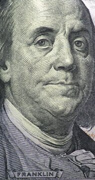 Changing 100 dollar bill with Franklin portrait stop motion. Benjamin Franklin portrait shifts across changing 100 dollar bill views in stop motion.