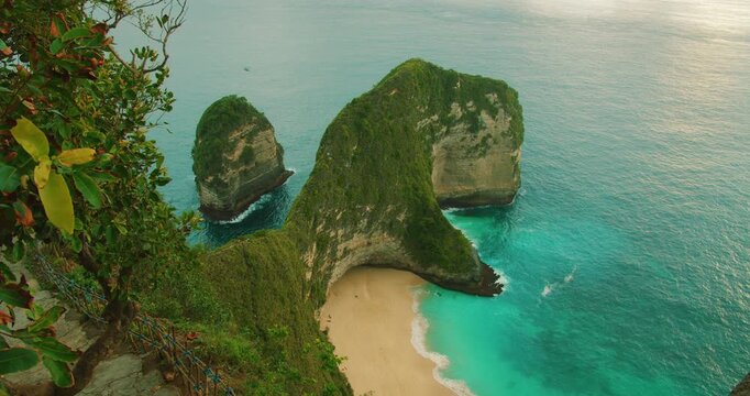 High cliff perspective overlooking empty beach and turquoise ocean water at Kelingking Beach Nusa Penida Bali