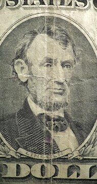 Historic banknote artwork reveals Abraham Lincoln portrait. Abraham Lincoln portrait appears on dollar bill in stop motion. 