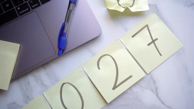Crumpling paper note with year 2026 to reveal 2027