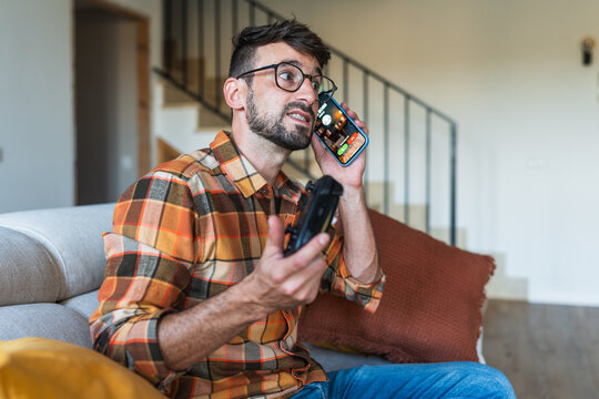 Man receiving call from boss while gaming at home