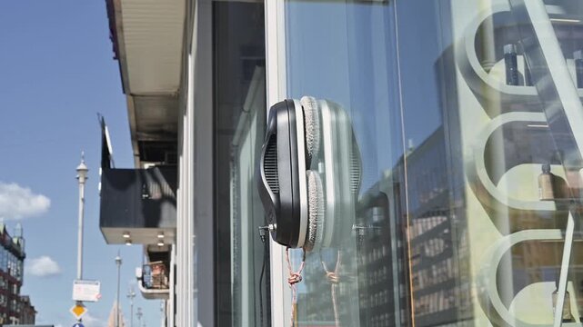 Compact vertical robot vacuum for cleaning outdoor display windows.
